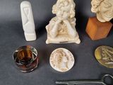a statue of a woman sitting on a chair next to other objects