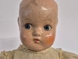 a small doll that is sitting on a white surface