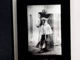 black and white photograph of a woman in a dress and a black box