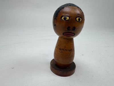 un petit jouet en bois sur lequel est dessiné un visage