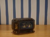 a small wooden box sitting on a table with blue and white stripes
