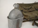 a bag and a canteen sitting on a table