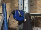 a blue hose attached to a wall next to a ladder