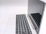 a white laptop with a black keyboard on a white table