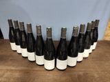 several bottles of wine are lined up on a wooden table