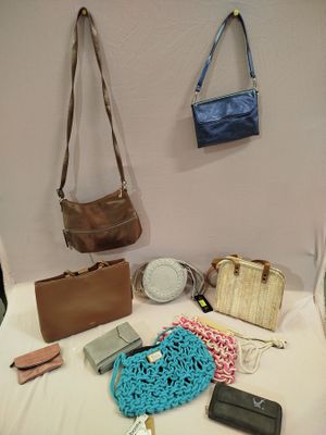 several purses and handbags are arranged on a bed
