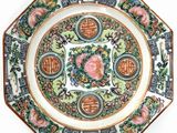 a decorative plate with a rose on it on a white surface