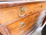a wooden dresser with brass handles on it