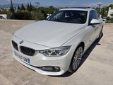 Une berline BMW Série 3 blanche garée dans un parking