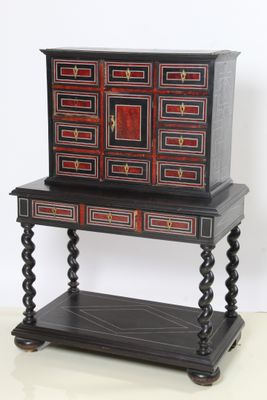 une photo d'une commode noire et rouge posée sur un meuble d'appoint