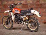 a dirt bike that is parked in front of a brick wall