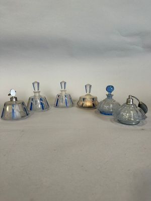 quatre petites bouteilles en verre avec des bouchons bleus et argentés