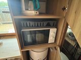 a microwave that is built into a cabinet in the kitchen