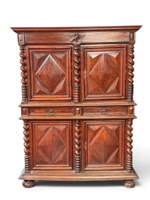 une vieille armoire en bois à quatre portes avec un dessus sculpté