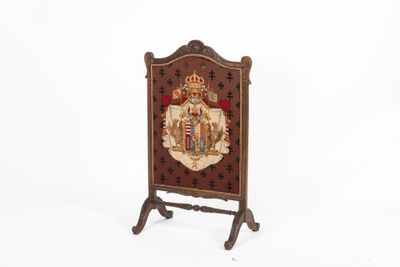 une image représentant une plaque en bois sur laquelle figurent des armoiries et une couronne
