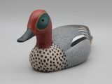 un petit canard en bois posé sur une table