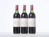 three bottles of red wine sitting next to each other on a table