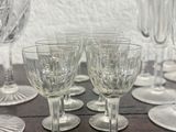 many wine glasses sitting on a table next to each other