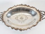 an antique silver plate with a decorative design on the rim