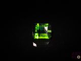 un gros plan d'une bague en verre vert posée sur une surface noire