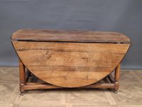 Table à battants en bois posant sur quatre pieds entretoisés