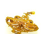 an image of a gold brooch with a butterfly on top of it