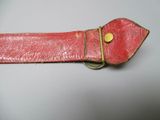 a red leather belt with a gold buckle on it