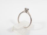 a close up of a diamond ring on a clear stand