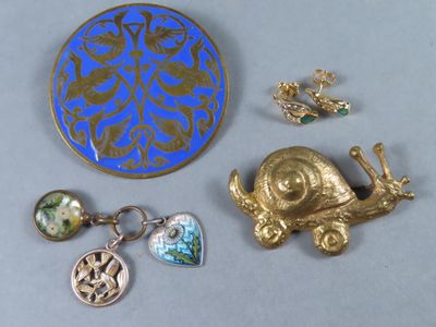 une broche bleue et dorée ainsi que d'autres bijoux posés sur une table