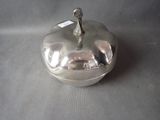a silver apple with a spoon in it on a table