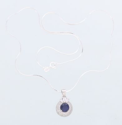un collier en argent orné d'une pierre bleue sur fond blanc