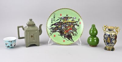 trois vases, une assiette et une théière posés sur une table
