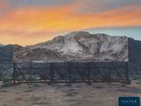 a billboard with a mountain in the background at sunset