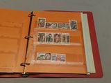 a red binder with stamps inside of it on a table