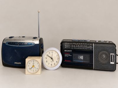 a clock, radio, and alarm sitting next to each other