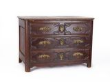 une commode en bois avec des ferrures en laiton sur les tiroirs