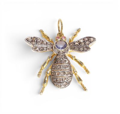une broche en forme d'abeille en or et diamants sur fond blanc