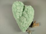 a green heart shaped stuffed animal next to other stuffed animals