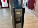 a water dispenser in the corner of a room