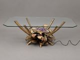 a glass table with a gold flower on top of it