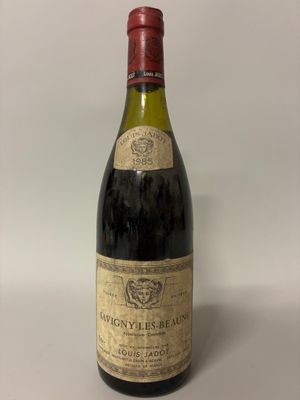 an old bottle of wine sitting on top of a white table