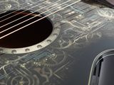 a close up of a black guitar with a design on it