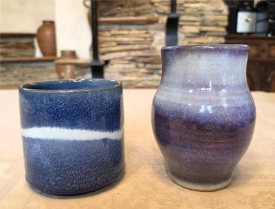 two vases sitting on a table next to each other