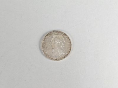 a close up of a silver coin on a white surface