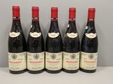 six bouteilles de vin sont alignées sur une table