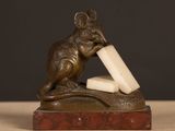 statue of a mouse with a block of cheese in its mouth
