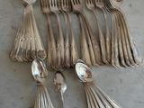 beaucoup de cuillères en argent et de cuillères à soupe sur une table