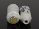 two white vases with blue designs on them