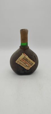 une petite bouteille avec une étiquette, posée sur une table