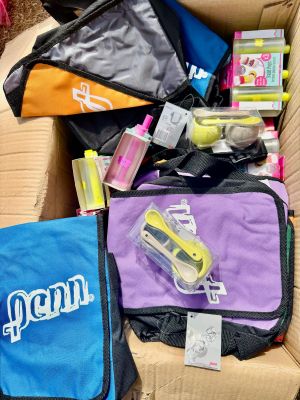 une boîte remplie de fournitures scolaires posée sur un canapé